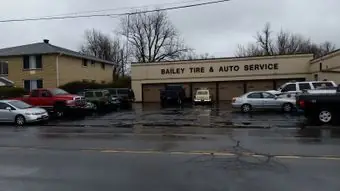 The Bailey Tire and Auto Service storefront on Englewood Avenue in Buffalo, with customer cars parked out front on a rainy day